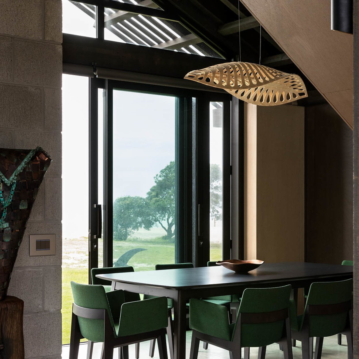 navicula light installed on double ceiling height above dining table