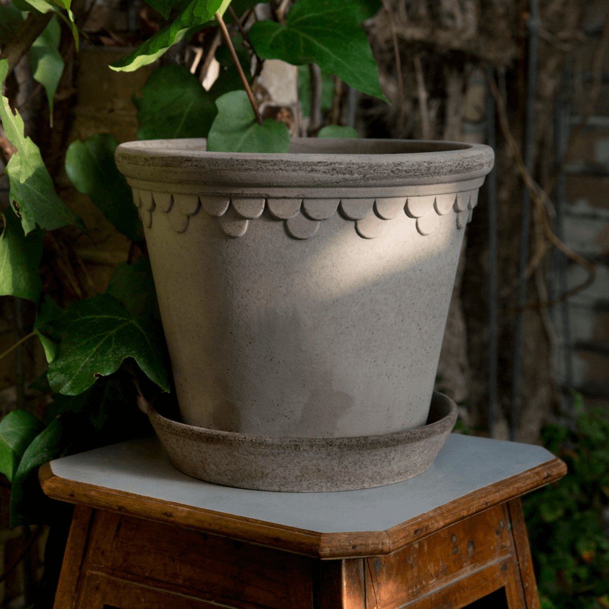 bergs potter grey copenhagen plant pot sat on side table in garden