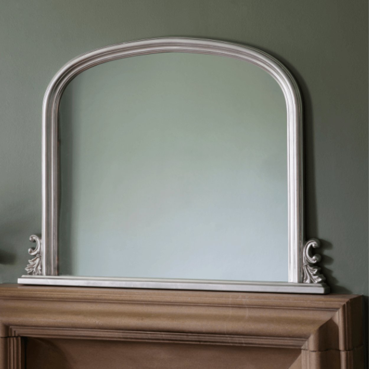 thornby silver arched mirror sitting on top of fireplace mantel